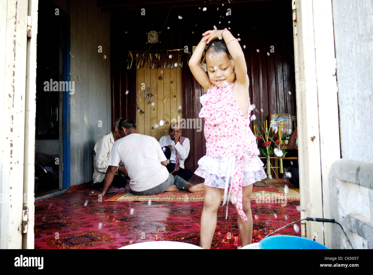 Girl, child, playing, taking a bath, Cambodian, home,sit, wall, Stock Photo