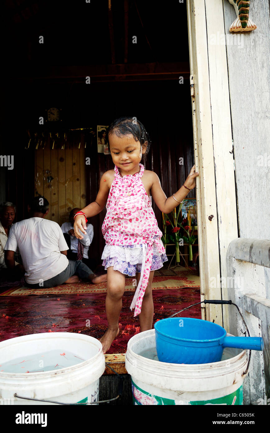 Girl, child, playing, taking a bath, Cambodian, home,sit, wall, Stock Photo