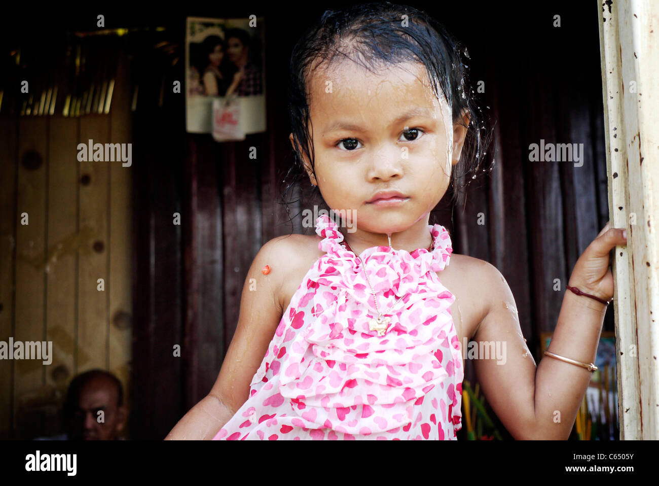 Girl, child, playing, taking a bath, Cambodian, home,sit, wall, Stock Photo