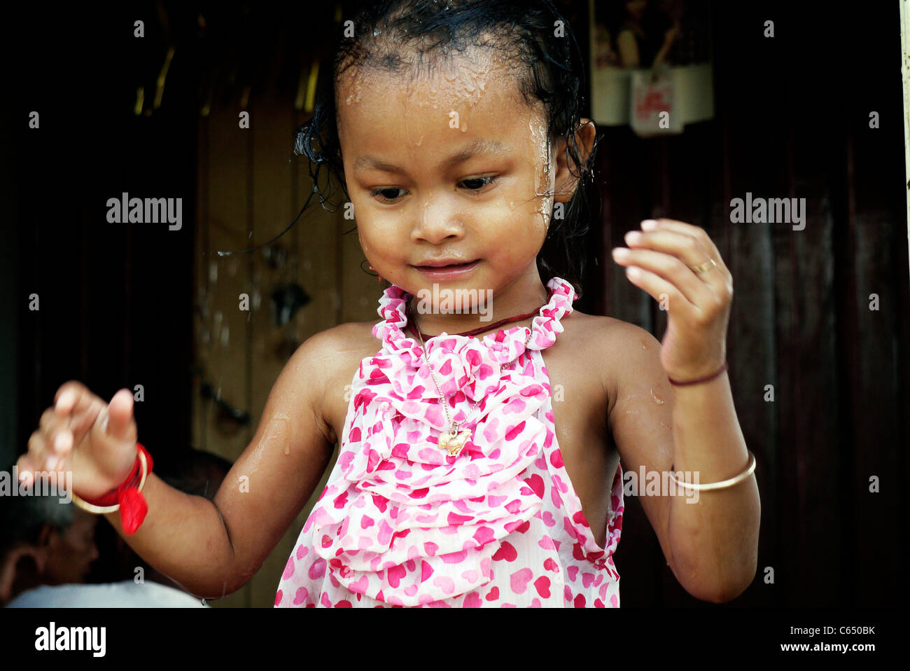 Girl, child, playing, taking a bath, Cambodian, home,sit, wall Stock ...