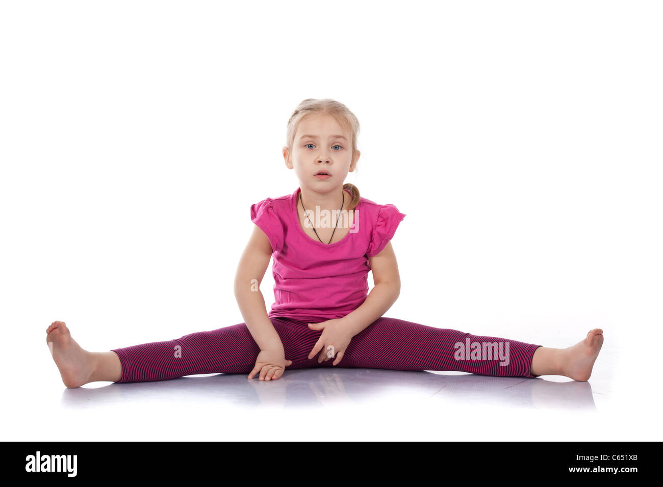 Studio portrait of girl gymnasts, sitting on the splits, isolation on