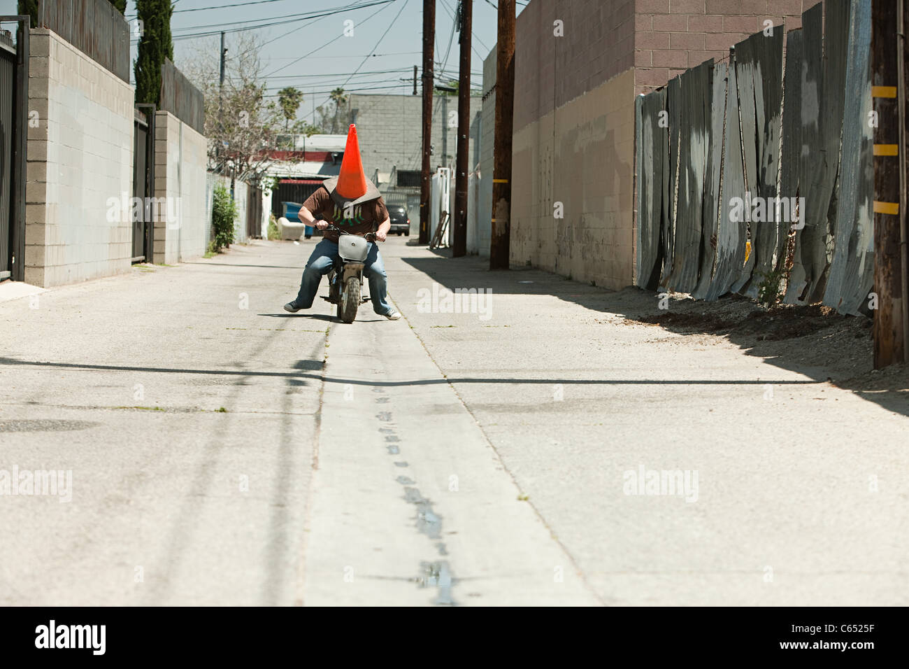 Man with traffic cone on head, riding motorbike Stock Photo Alamy