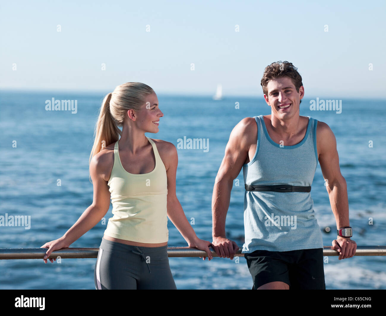 Resting On Railing Young couple resting on railings Stock Photo - Alamy