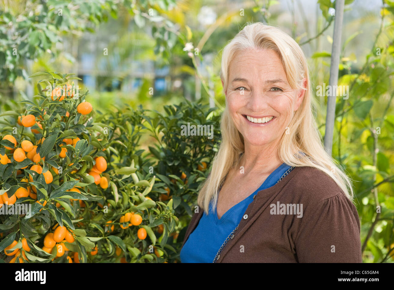 Mature woman by fruit tree Stock Photo