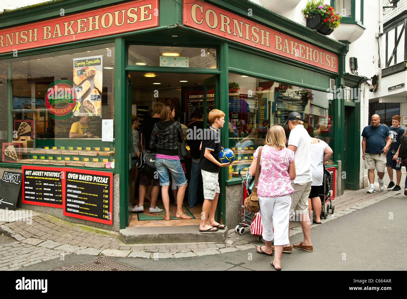 People queuing to buy take-away food at a Cornish pasty shop in Looe, a ...