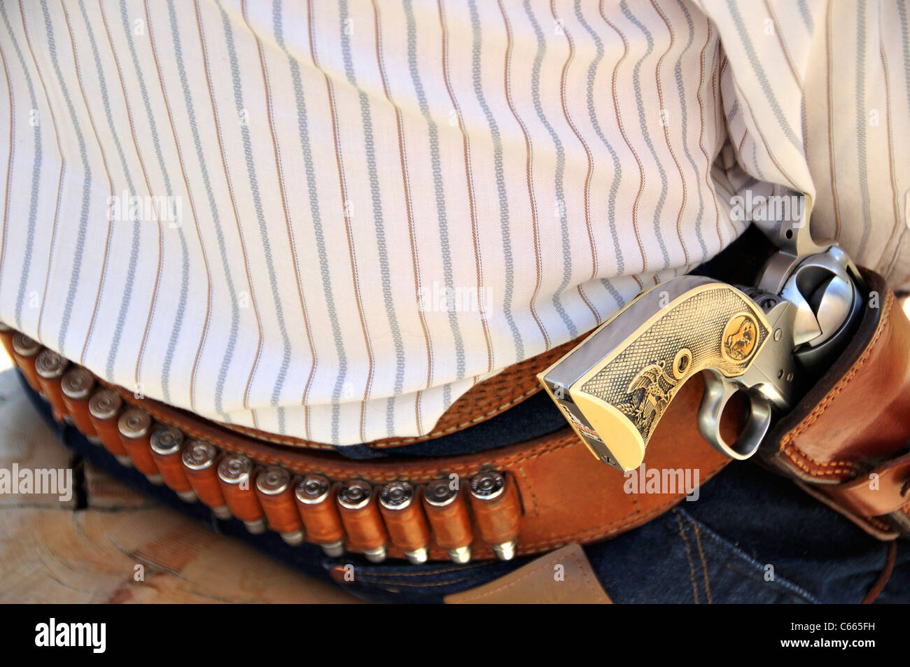 Traditional Colt-style single action revolvers in holsters at a fast draw contest Stock Photo