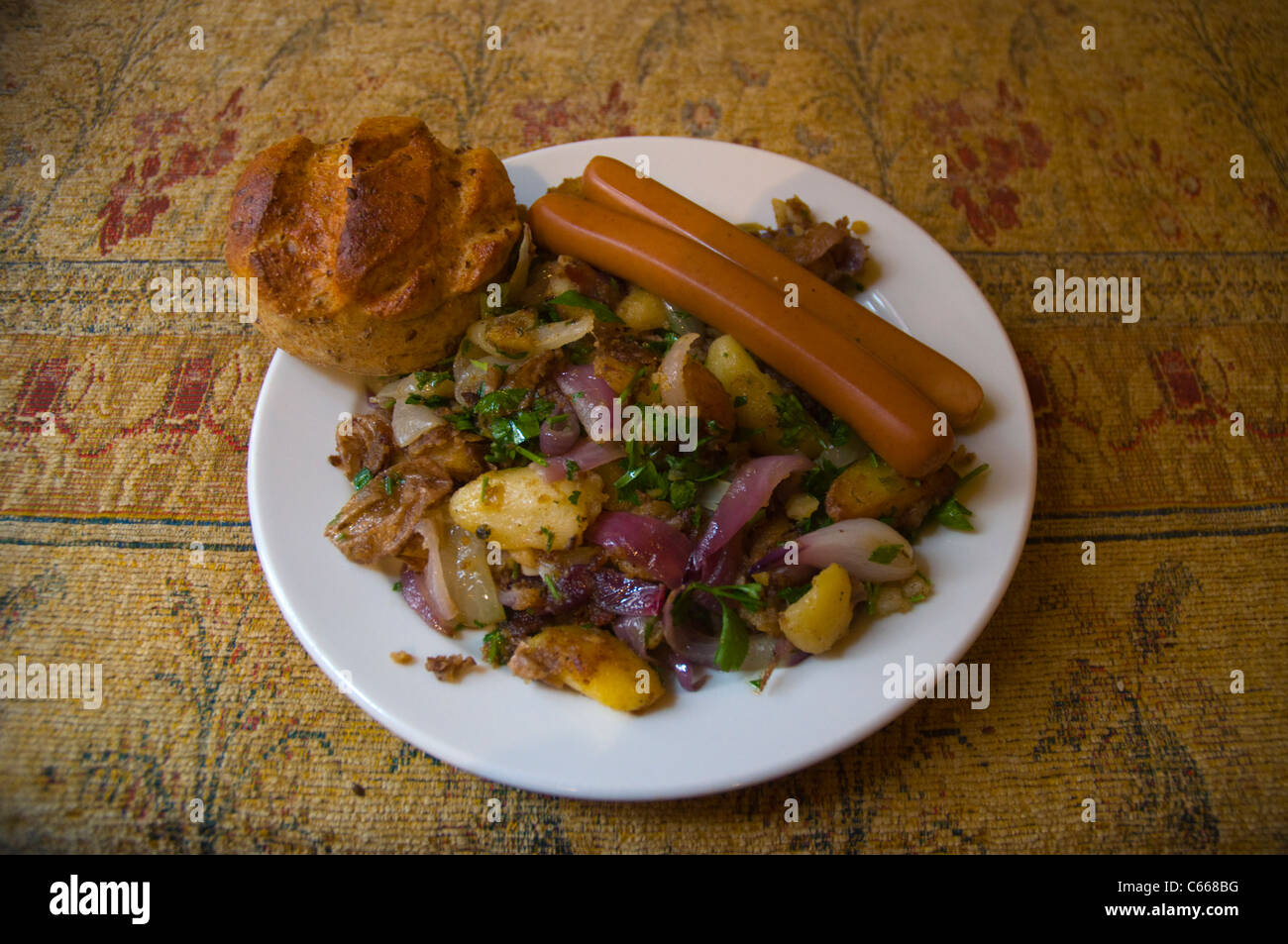Vegetarian sausages with fried potatoes and Hungarian bread roll