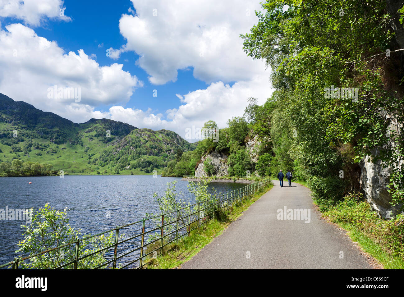 Couple walking along the banks of Loch Katrine in the Trossachs National Park, Stirling, Scotland, UK Stock Photo
