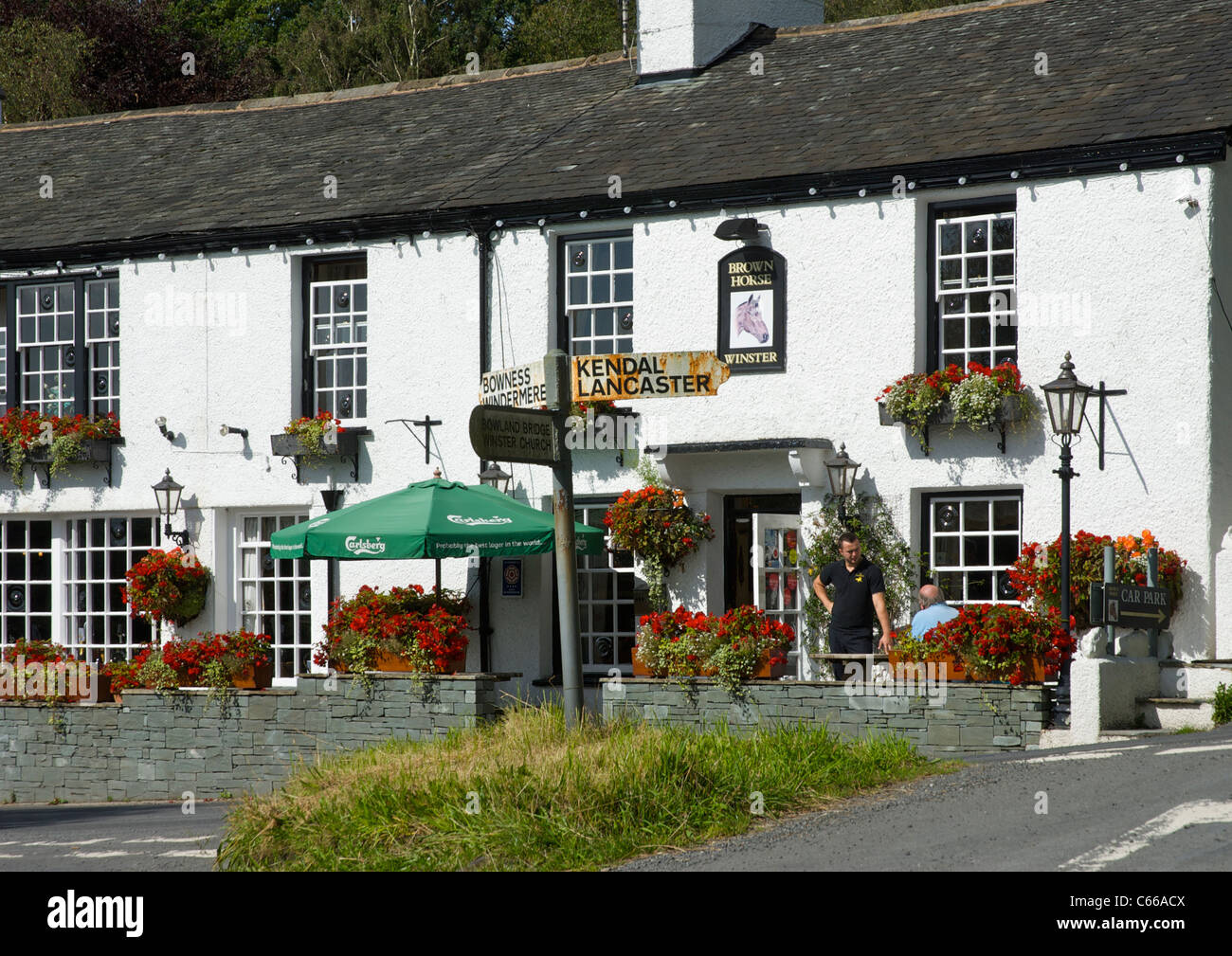 Two men outside the Brown Horse pub in the village of Winster, Lake District National Park, Cumbria, England UK Stock Photo