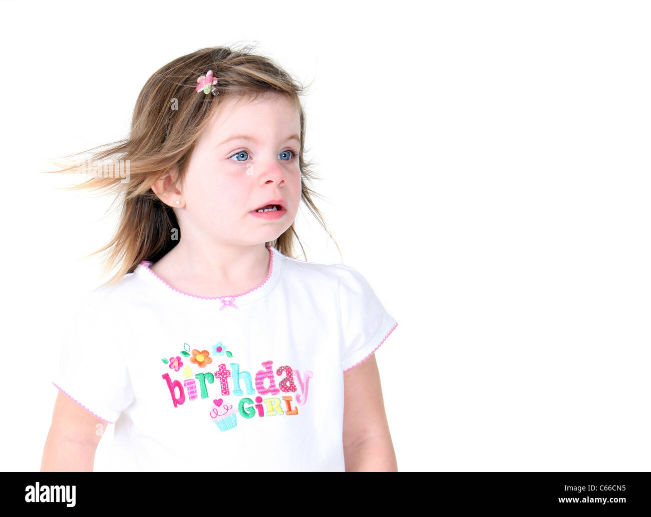 Toddler girl with wind blown hair isolated on white background Stock Photo