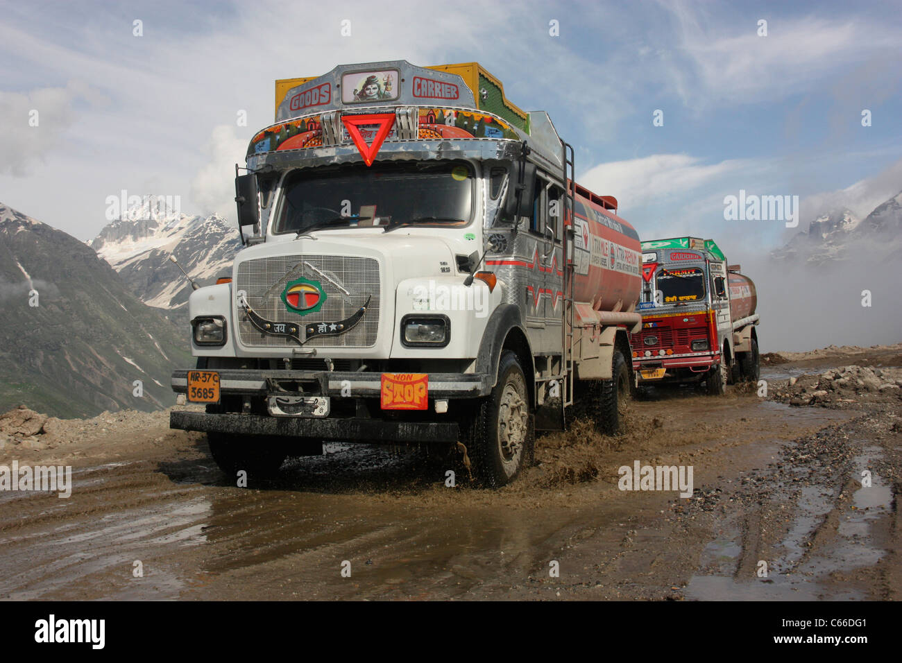 Decorated fuel tankers negotiate the hazardous Rhotang Pass on the road to Leh with a Himalayan backdrop. Ladakh India Stock Photo