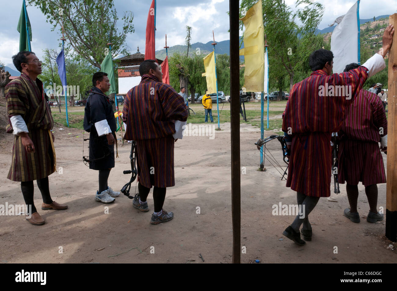 group of men wearing traditional gho on archery ground. Paro. Bhutan Stock Photo