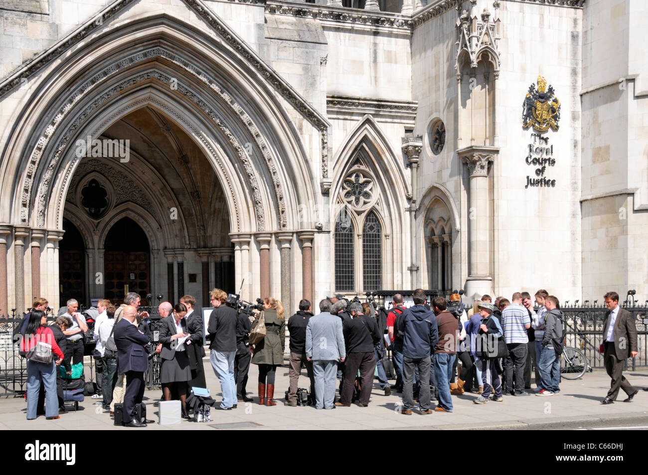 Crowd of media people including journalists reporters cameramen photographers & spectators on pavement at Royal Courts of Justice Strand London UK Stock Photo