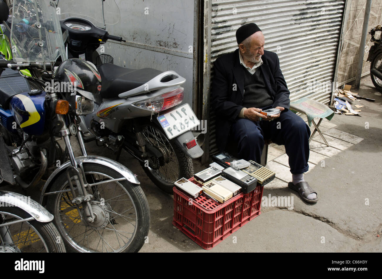 Old man selling Transistor radios outside a shop in downtown Tehran, Iran Stock Photo