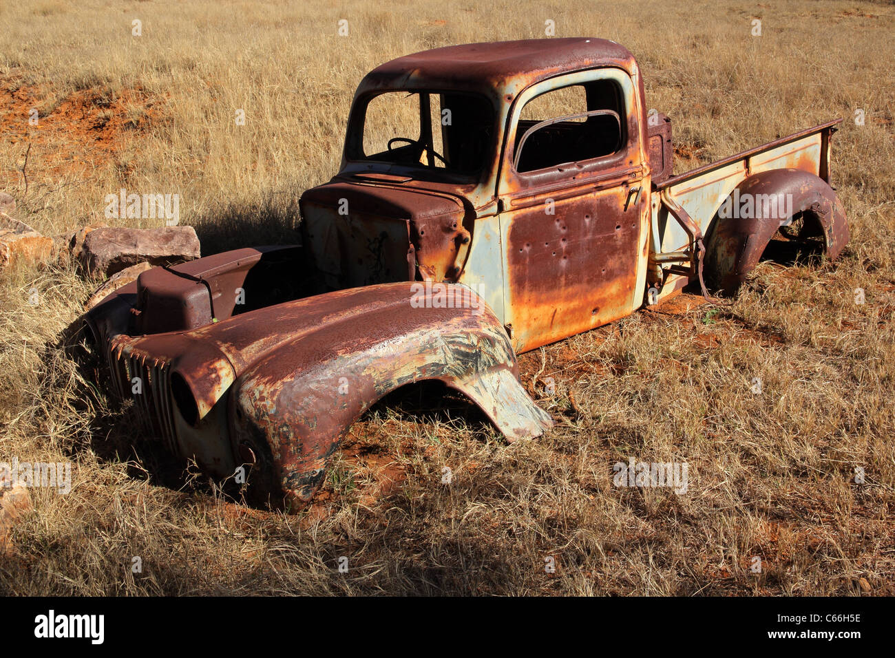 Wreck of a rusty old pickup truck out in the field Stock Photo
