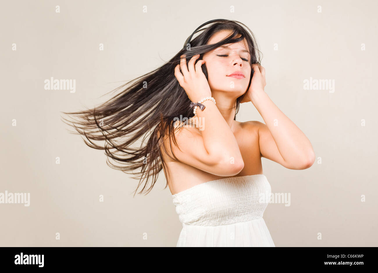 Gorgeous young brunette immersed in music wearing headphones, with eyes closed Stock Photo
