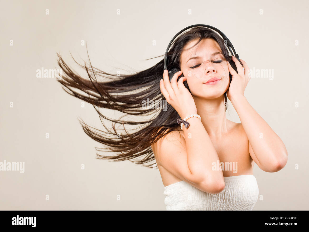 Gorgeous young brunette immersed in music wearing headphones. Stock Photo