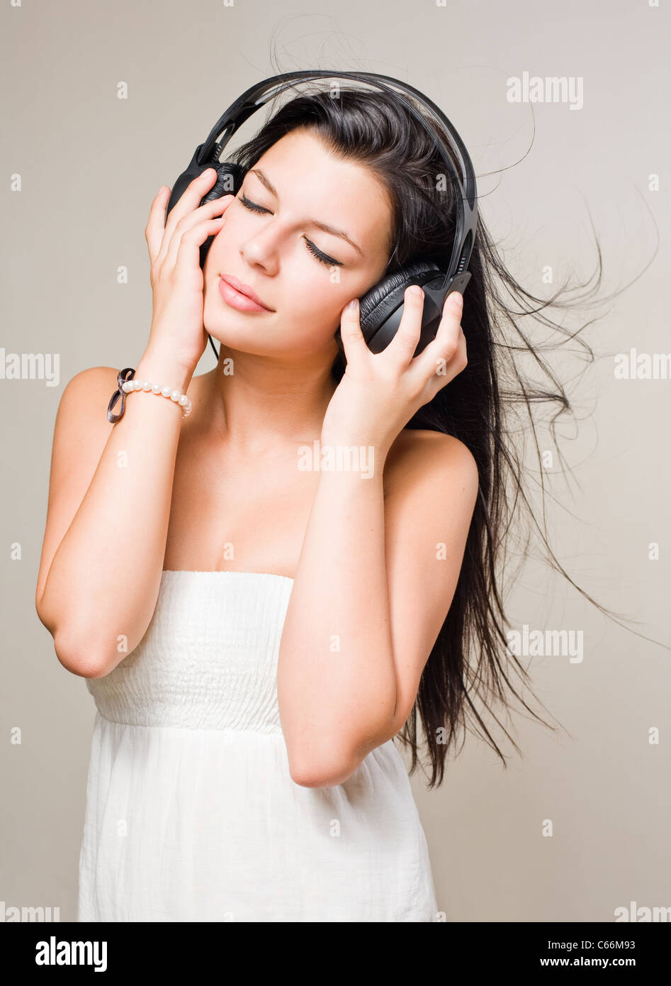 Gorgeous young brunette immersed in music wearing headphones. Stock Photo
