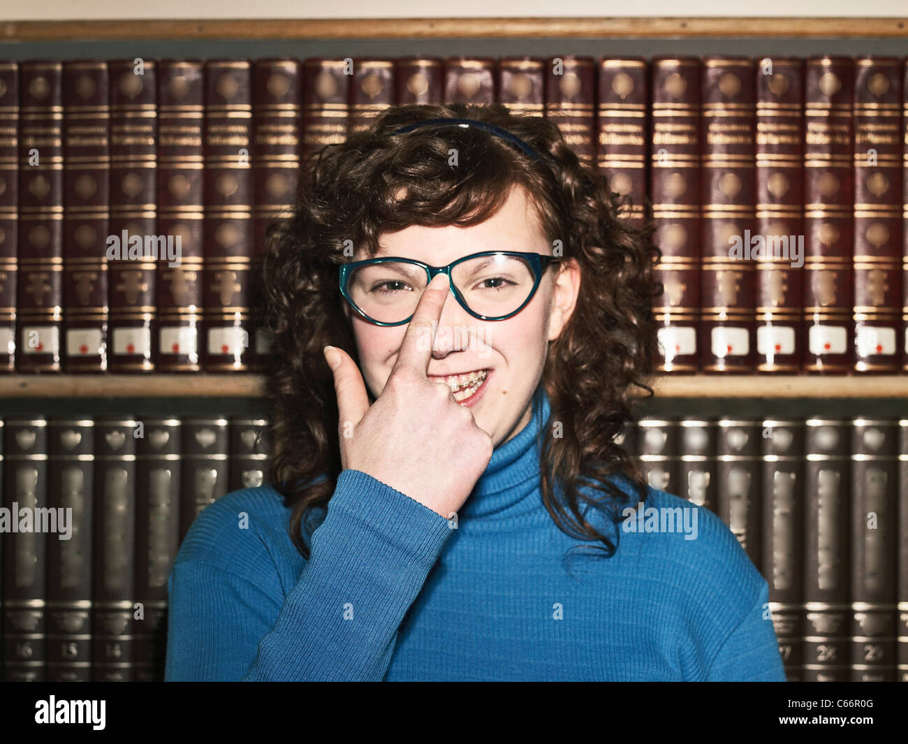 Woman pushing up glasses in library Stock Photo