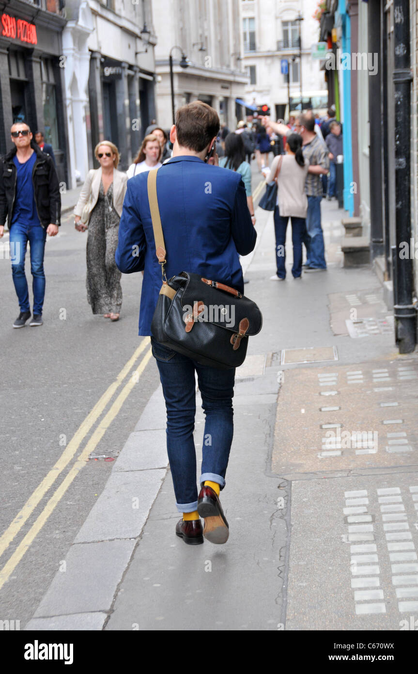 London style fashion skinny jeans young man manbag stylish Stock Photo -  Alamy