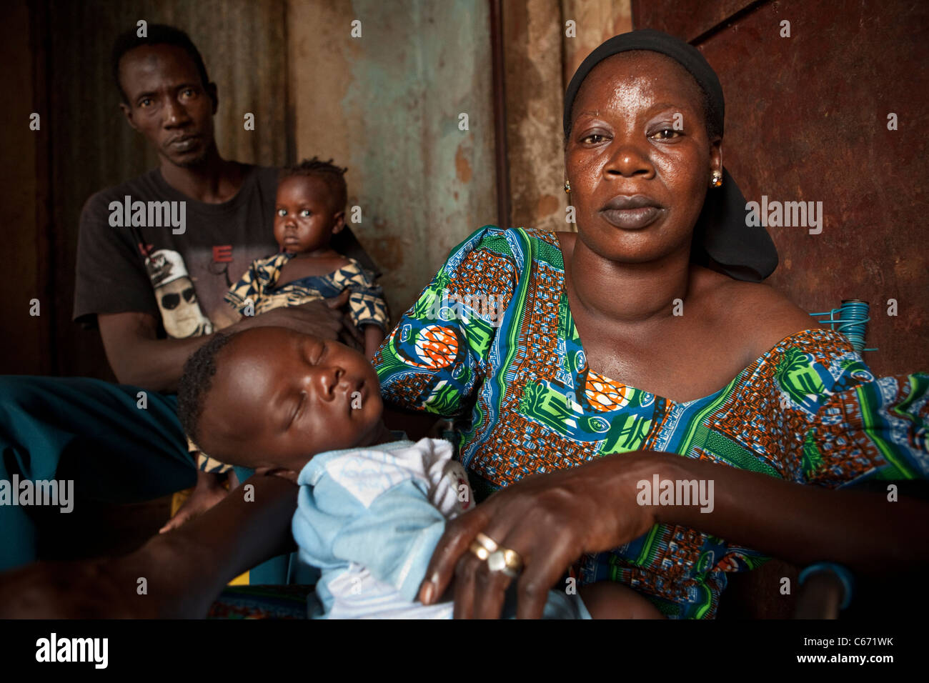 A family sits inside their home in a slum in Bamako, Mali, West Africa. Stock Photo