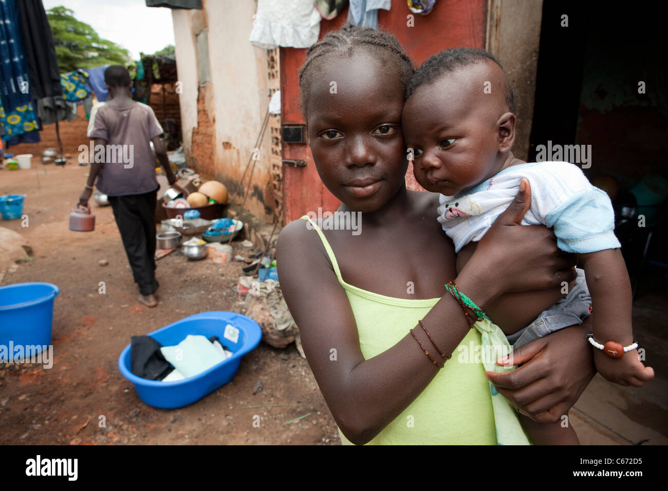 A girl holds a young child in a slum in Bamako, Mali, West Africa. Stock Photo