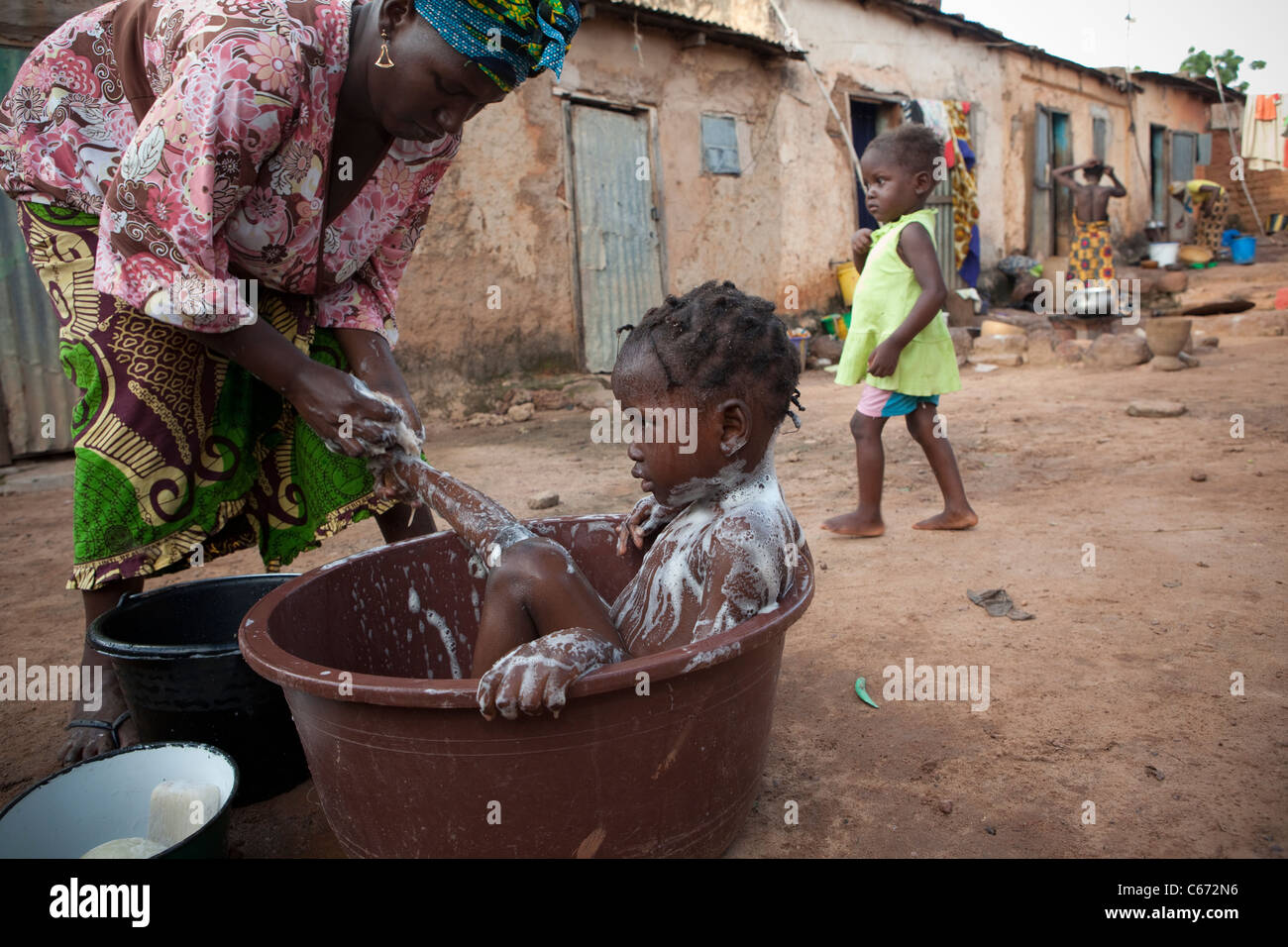 A mother bathes her child in a slum in Bamako, Mali, West Africa. Stock Photo