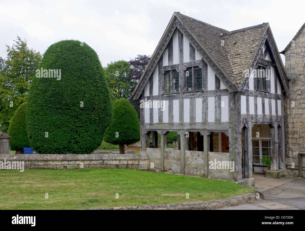 Old half-timbered building in the grounds of St Mary's Parish Church in the Cotswolds village of Painswick, Gloucestershire Stock Photo