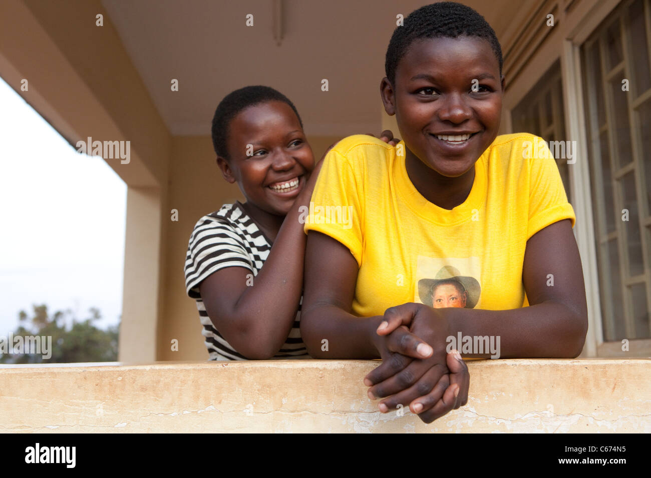 School girls wait outside a health care centre in Kampala, Uganda, East Africa. Stock Photo