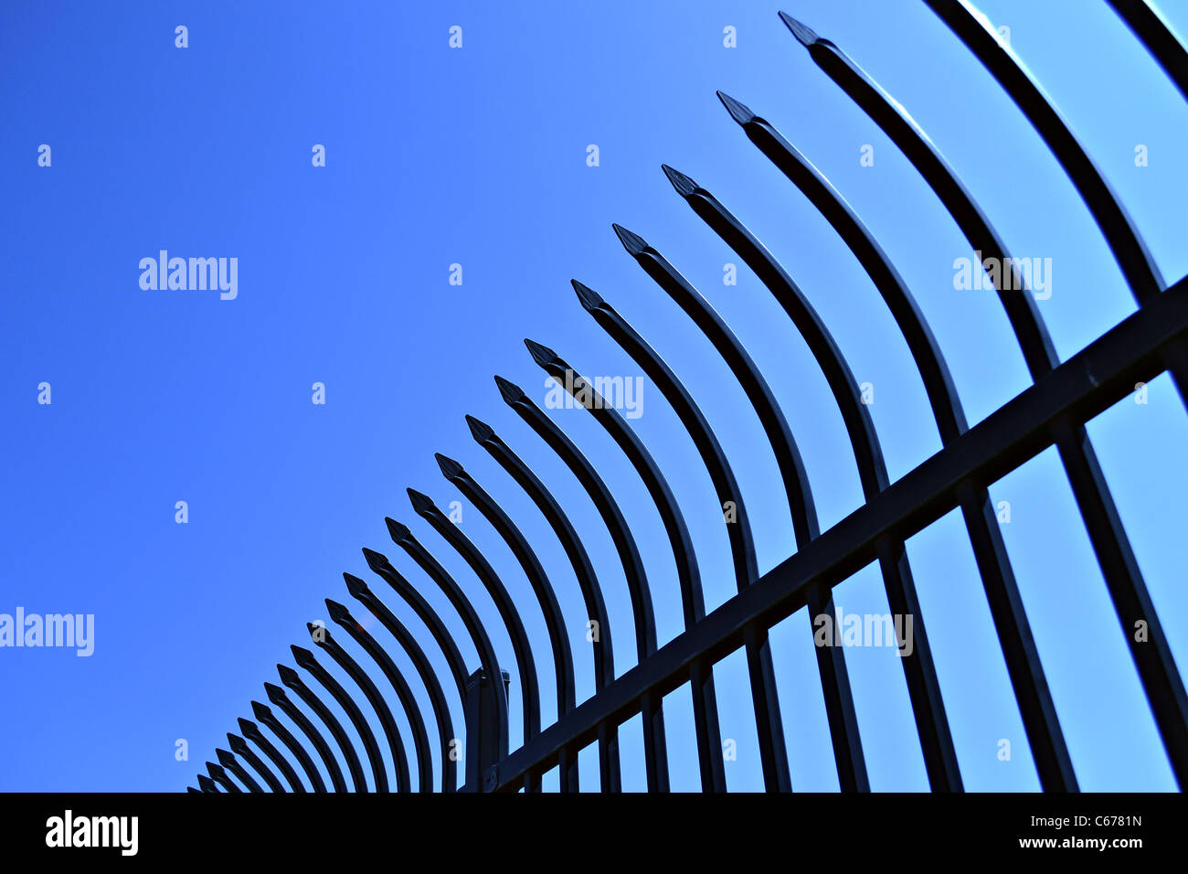 A view of curve spikes on top of a fence. Stock Photo