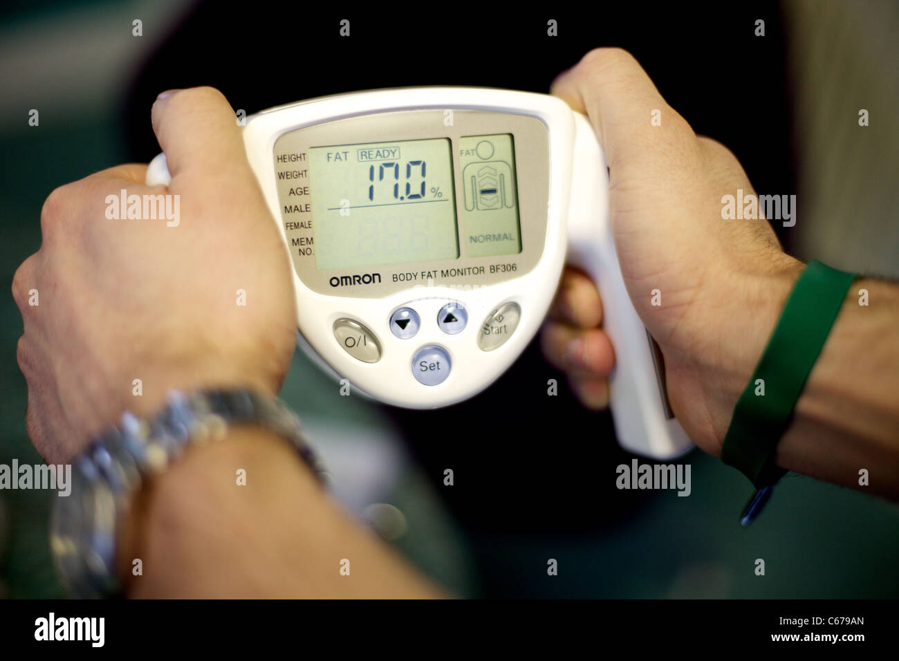 Hands holding an Omron Body Fat Monitor BF306 Stock Photo - Alamy