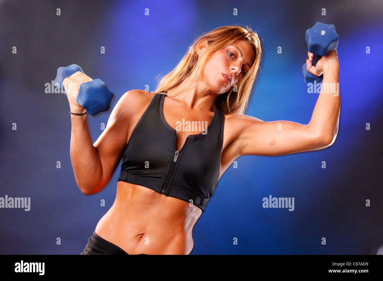 Toned blond working out with dumbells Stock Photo