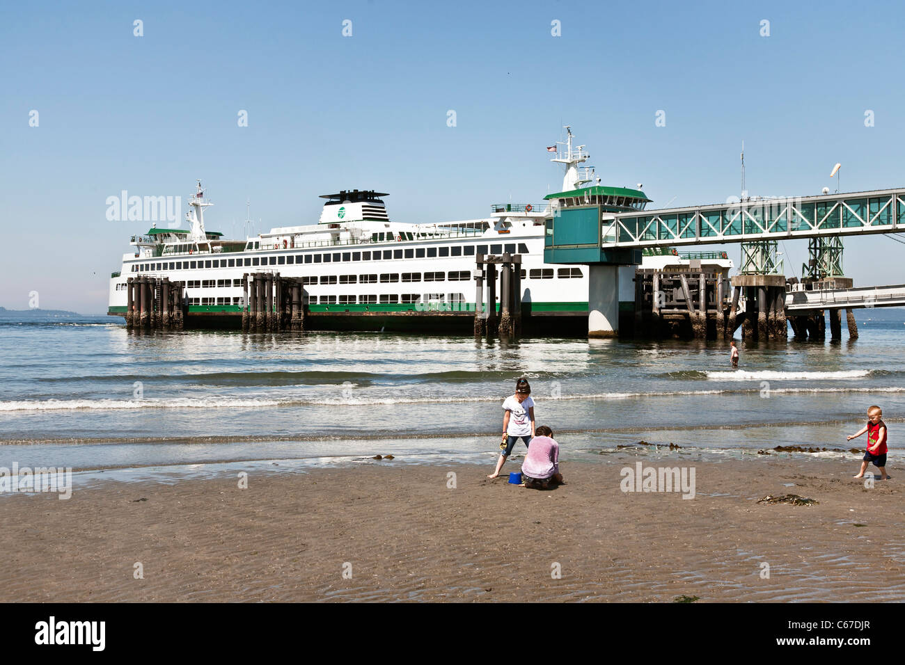 Children Playing Happily On Sandy Beach Next To Ferry Slip
