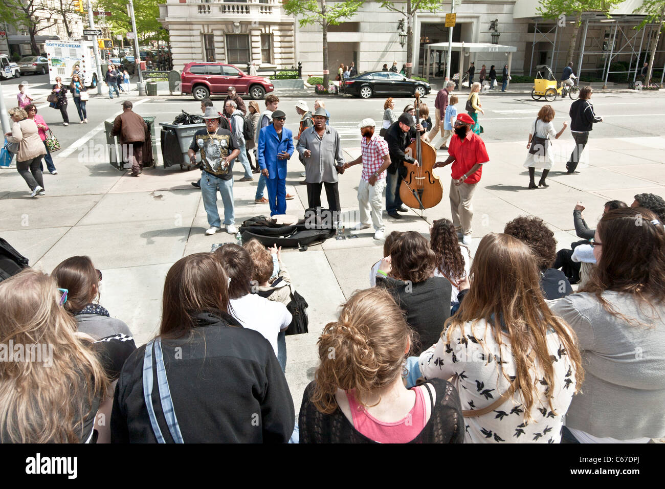 street band with white double bass player & 5 black vocalists performs
