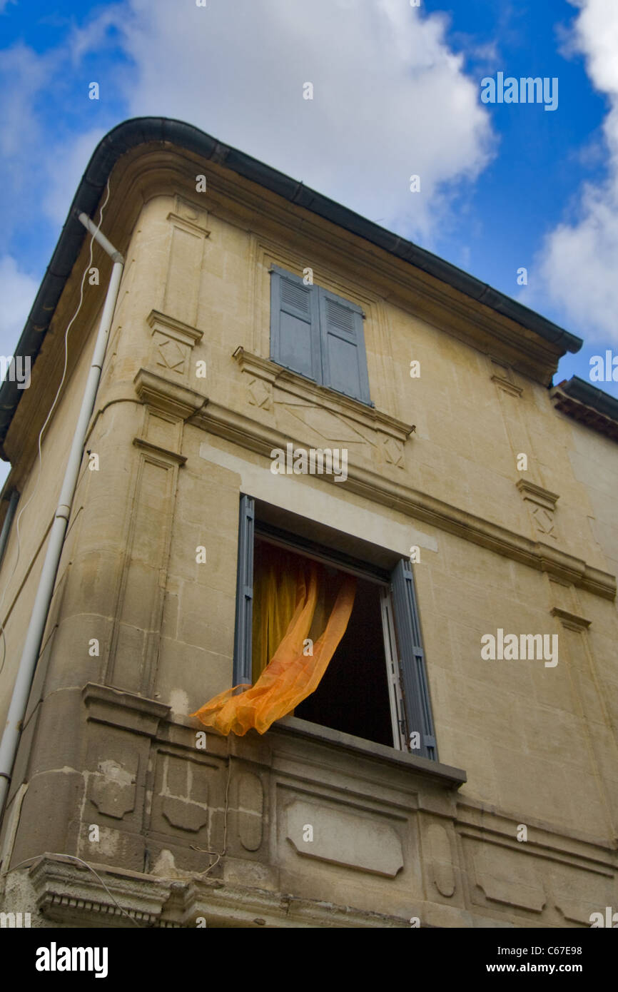 Open window with orange valance in stone house Stock Photo