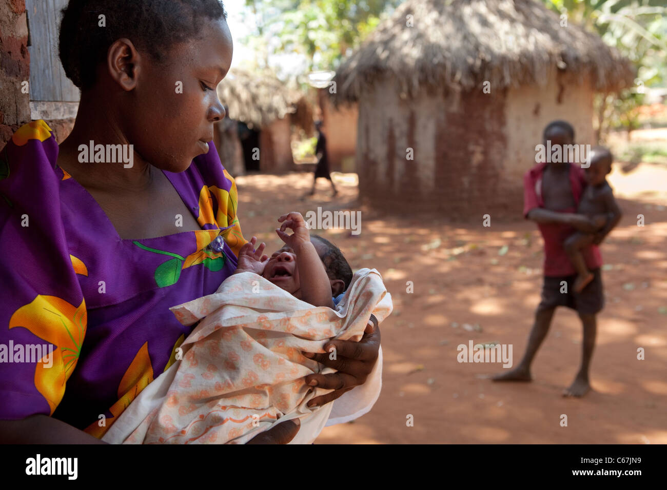 A woman holds an infant child in a village outside Kamuli, Uganda, East Africa. Stock Photo