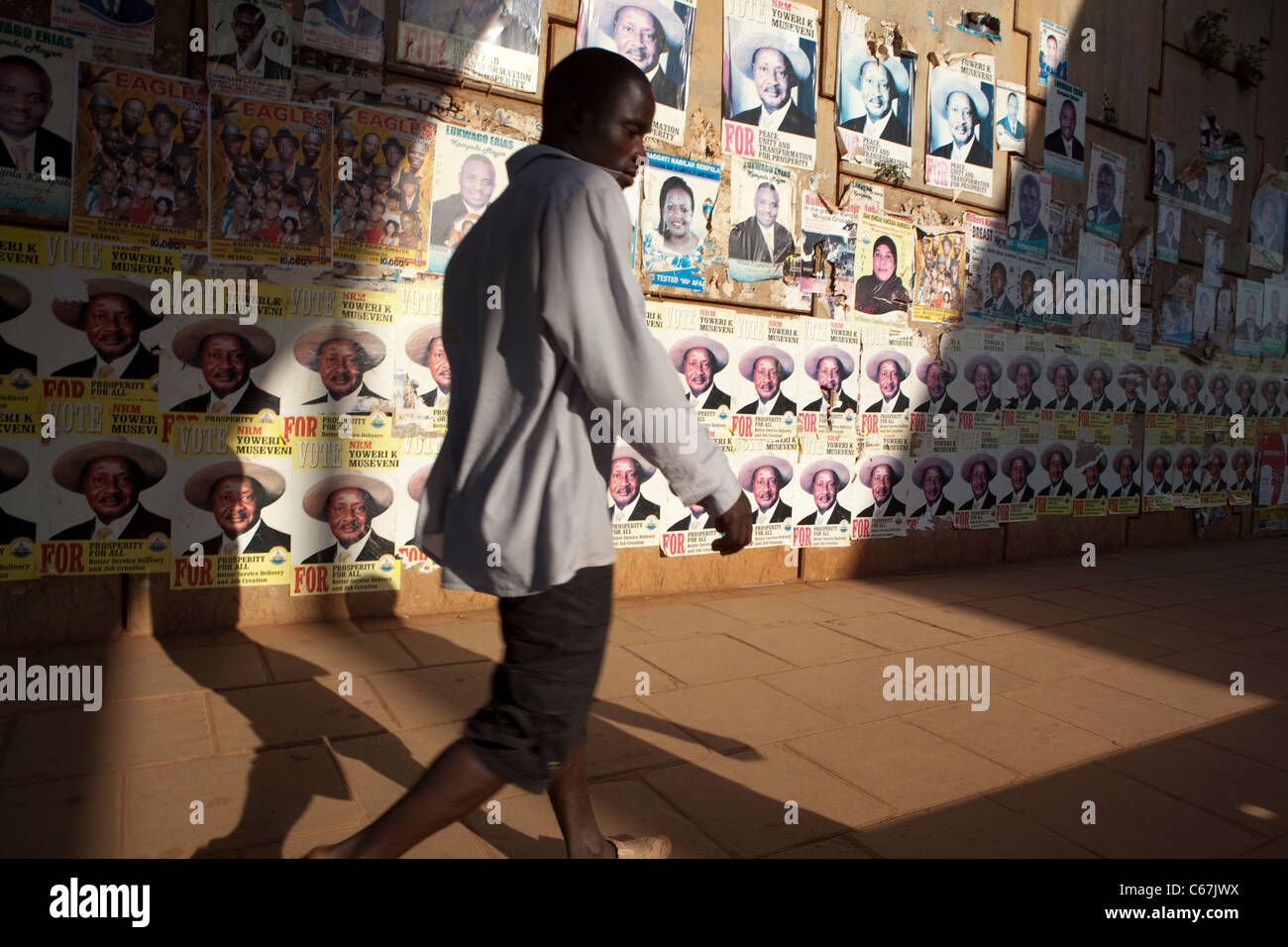 A pedestrian walks past election campaign posters in Kampala, Uganda, East Africa Stock Photo