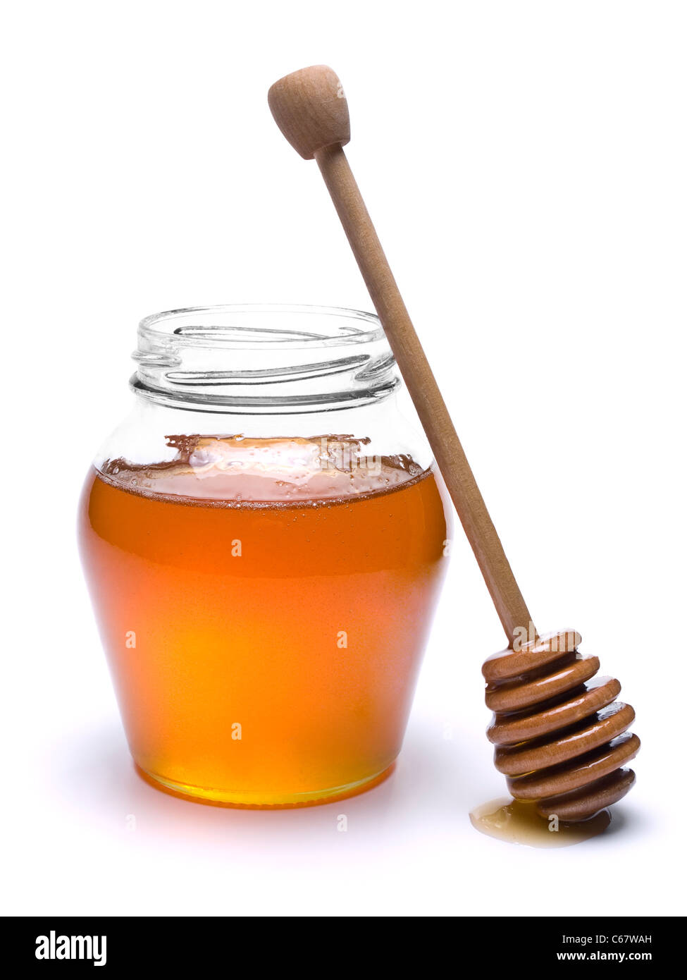 Jar of honey with a wooden drizzler a side. Isolated on white