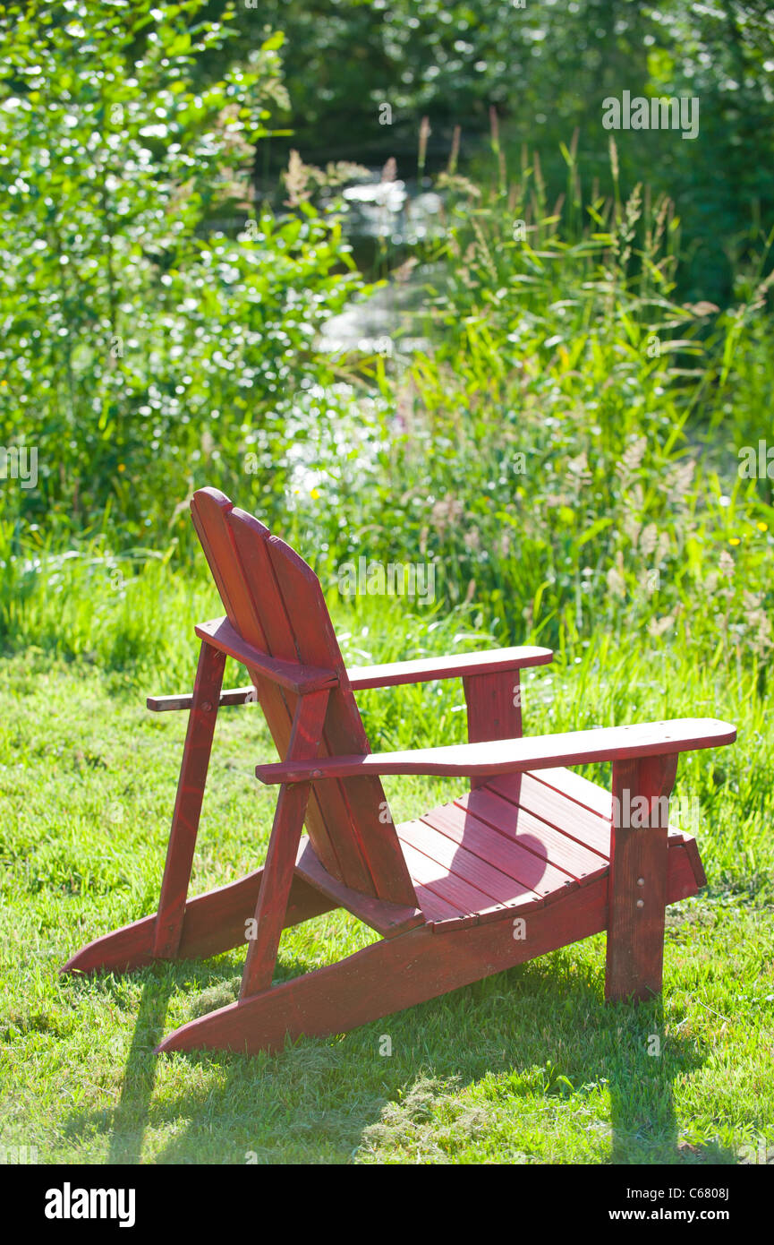 Red Adirondack chair by creek Stock Photo Alamy