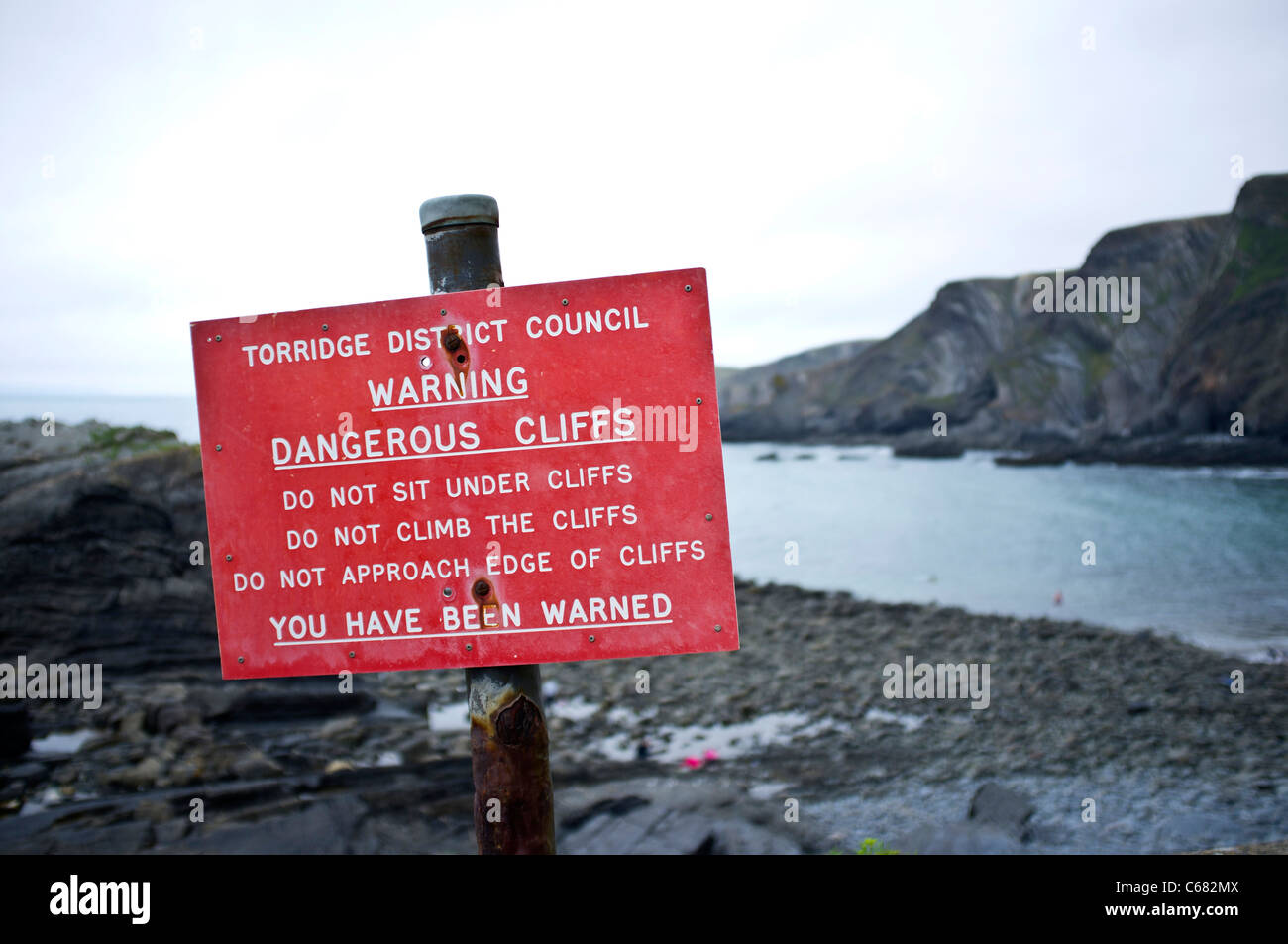 Warning sign at Hartland Quay about the dangerous cliffs around the beach in Devon Stock Photo