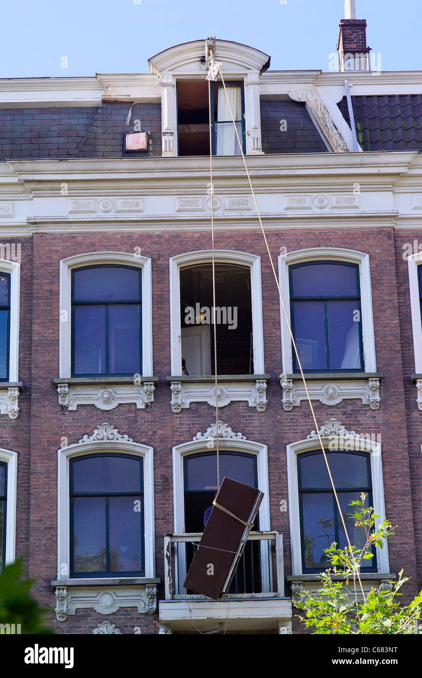 Traditional way of lifting furniture upstairs in Amsterdam - lifting with single pulley Stock Photo