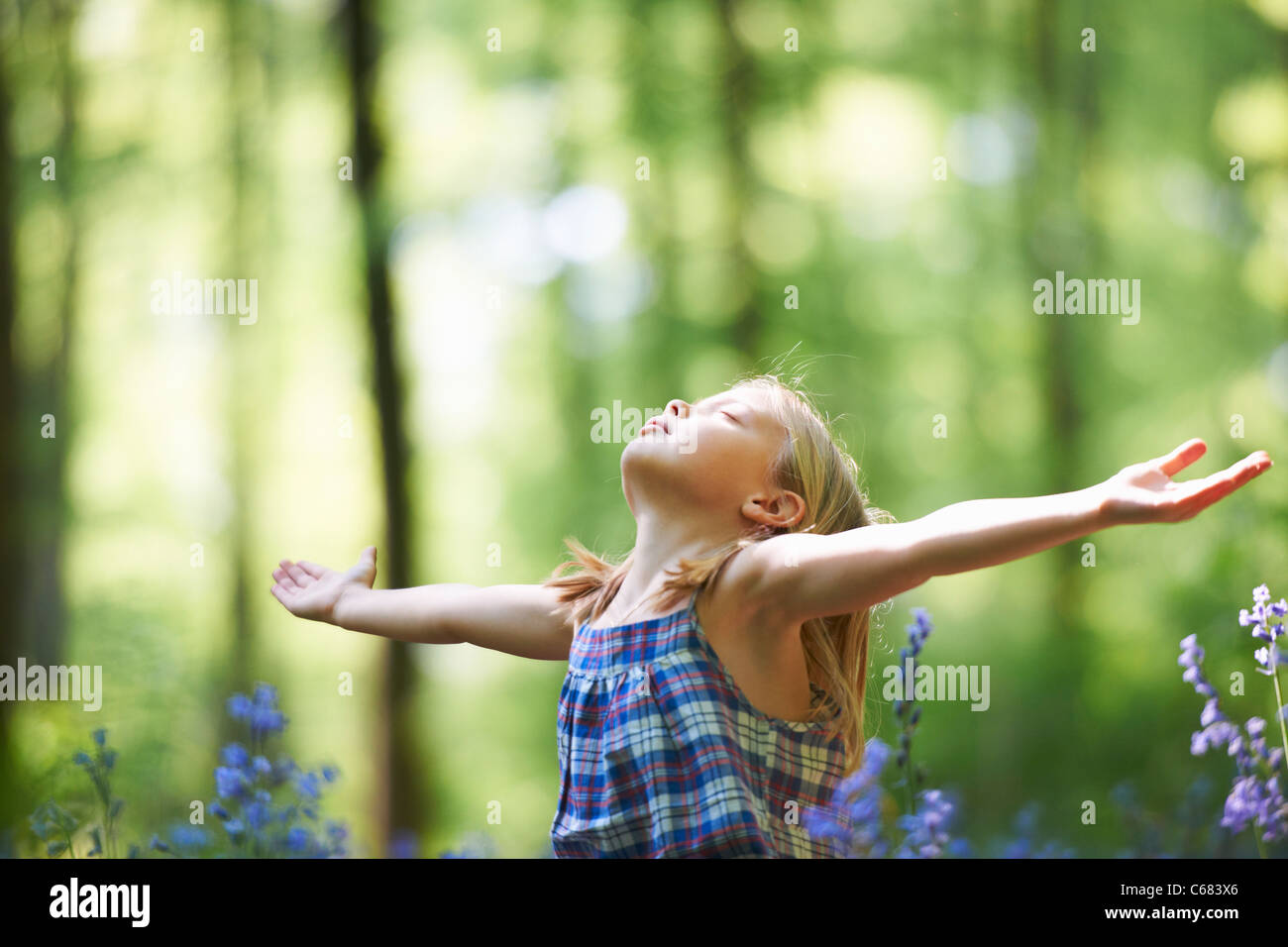 Girl standing in field of flowers Stock Photo - Alamy