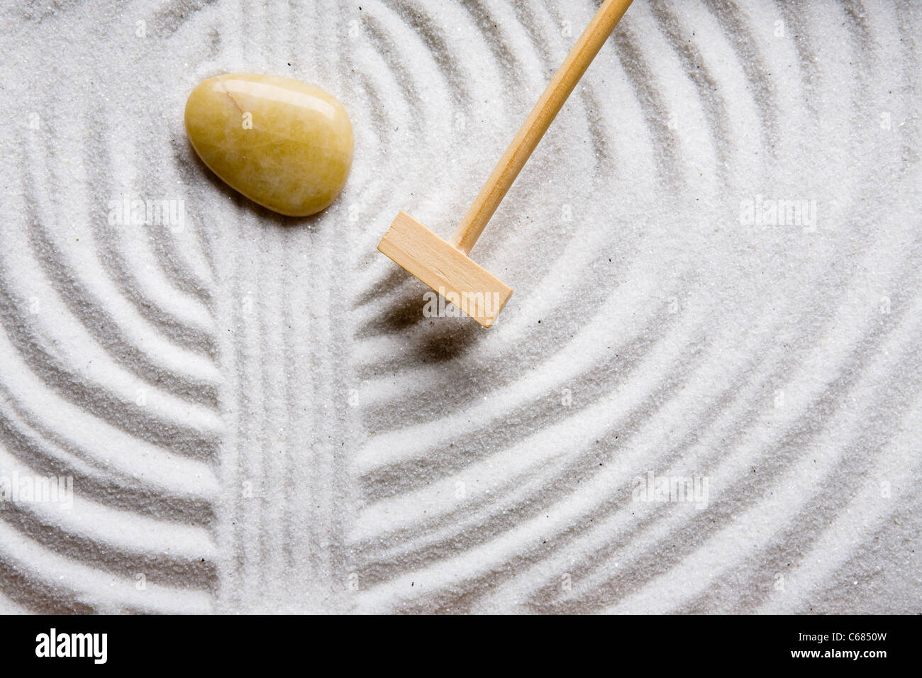 A rake in a zen rock garden, preparing the sand Stock Photo Alamy