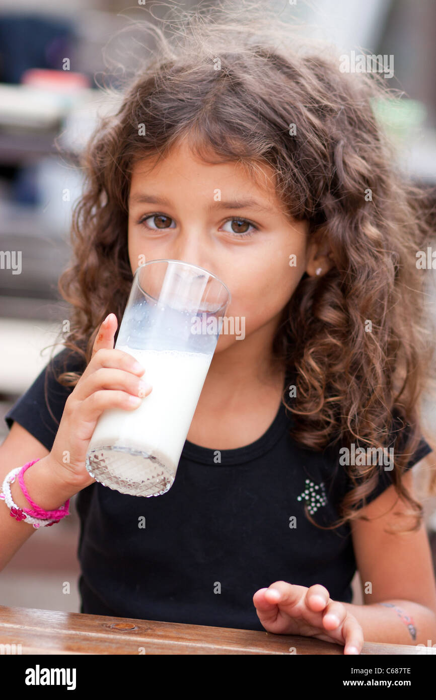 Cute little girl drinking a glass of milk Stock Photo