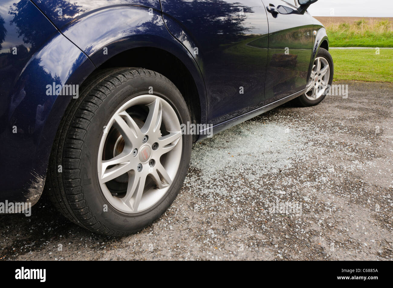 Broken glass underneath a car after its window is smashed by thieves Stock Photo