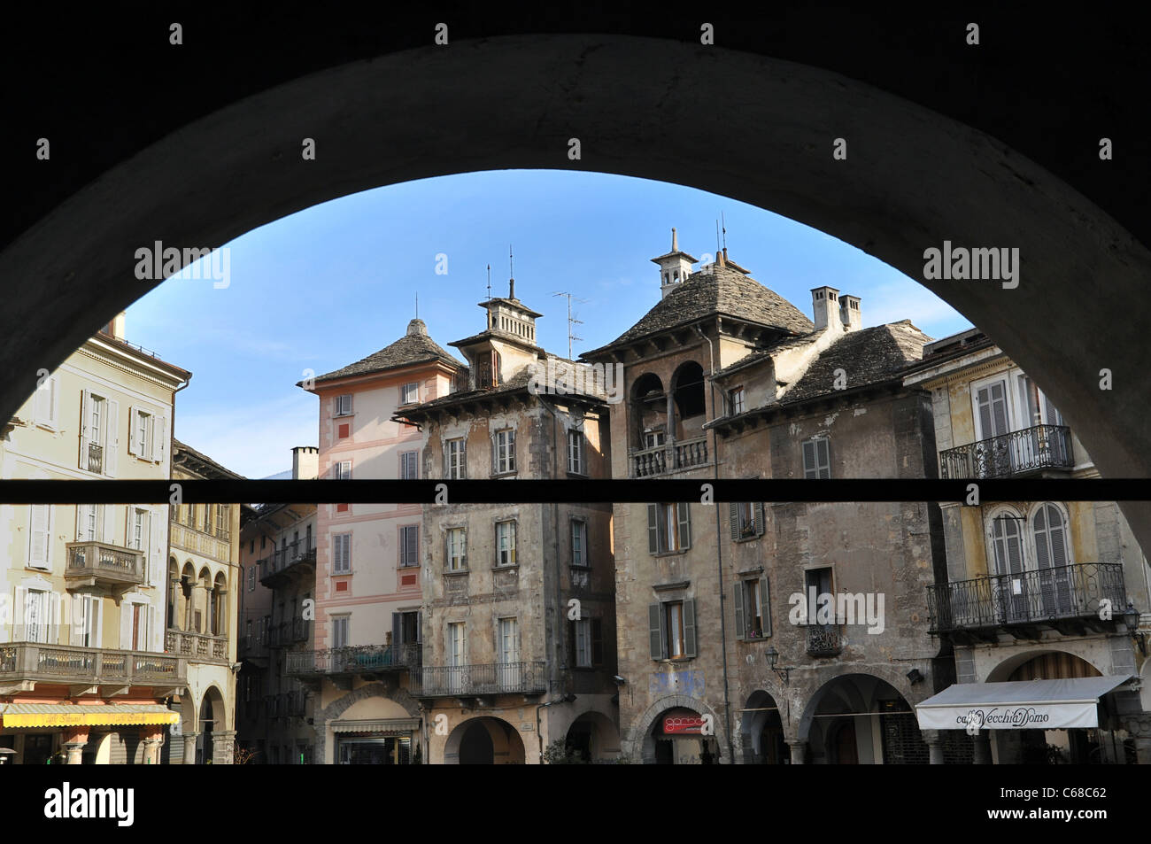Piazza Mercato in the center town of Domodossola with its old buildings viewed from the side colonnade, Verbania, Italy Stock Photo