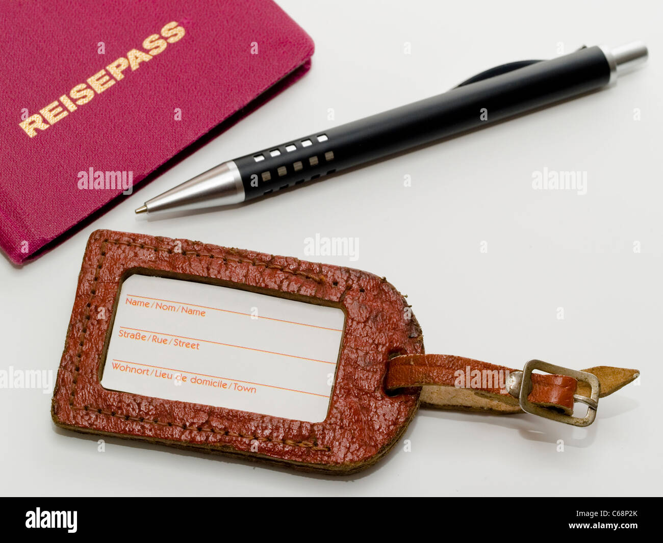 alter Kofferanhänger, daneben liegt ein Reisepass und ein Stift | old luggage label, a passport and a pen lies besides this Stock Photo