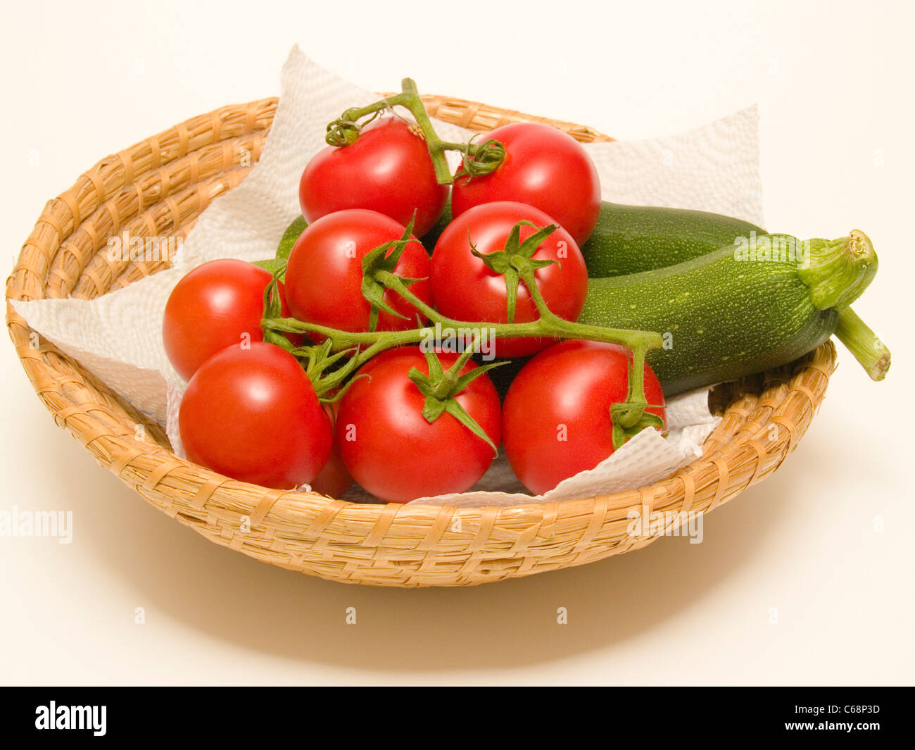 ein Korb mit einer Zucchini und Tomaten | a basket with a zucchini and tomatoes Stock Photo