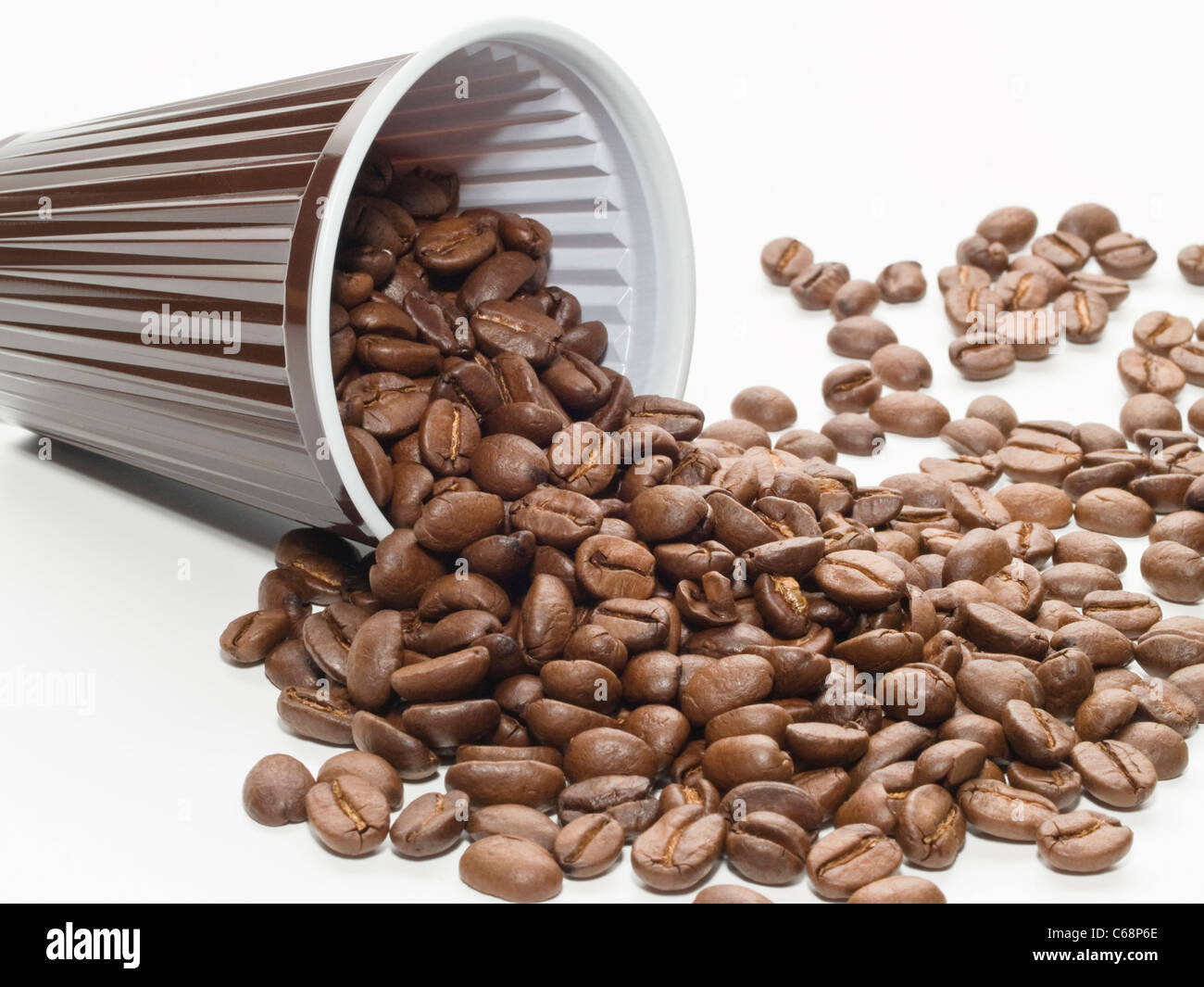 ein umgefallener Plastikbecher mit Kaffeebohnen | an toppled plastic cup with coffee beans Stock Photo