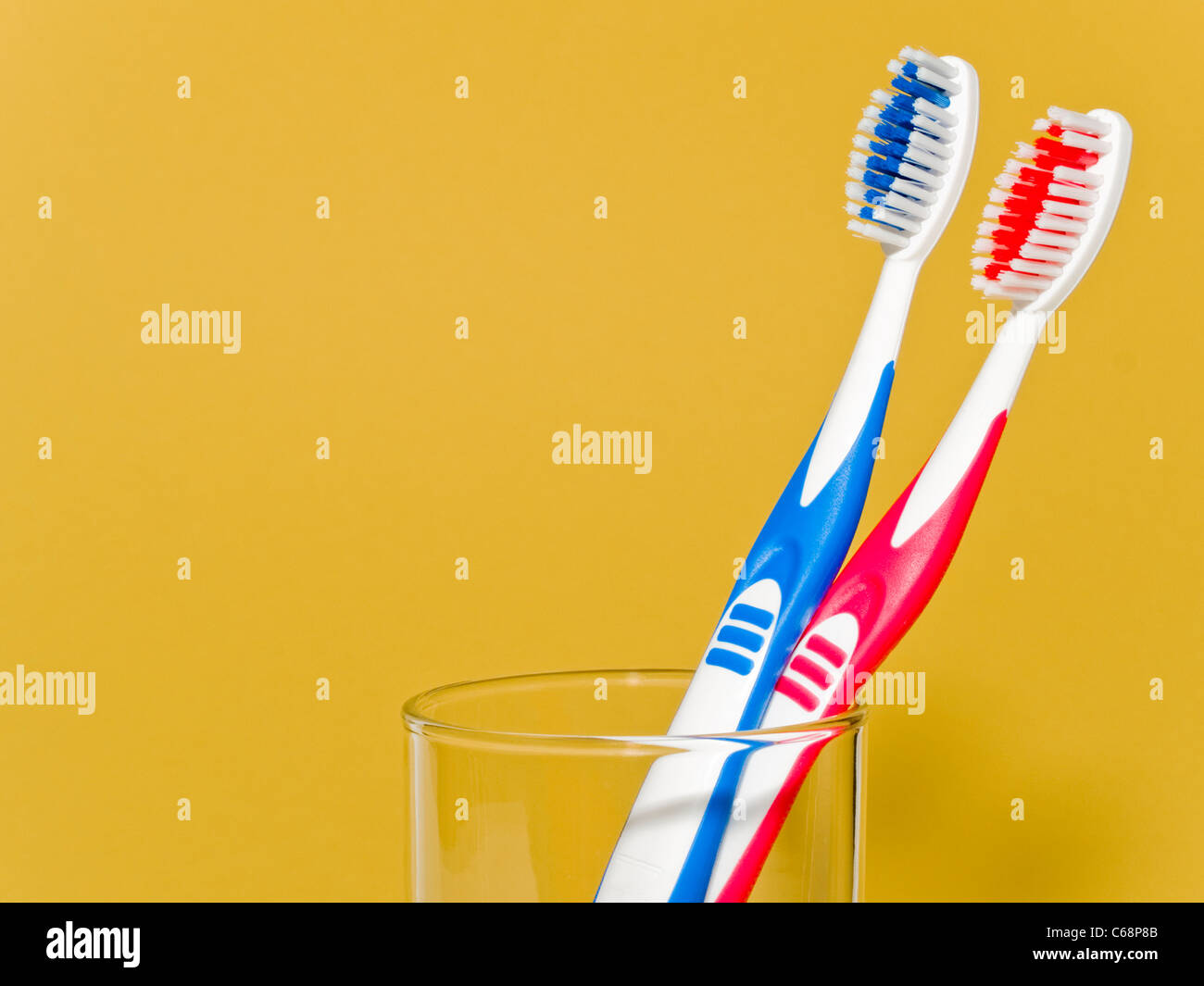 detail view of a blue and a red toothbrush in a glass Stock Photo